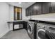 Well-equipped laundry room with cabinetry, sink, and high-efficiency washer and dryer at 10381 E Loving Tree Ln, Scottsdale, AZ 85262