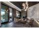 Inviting living room boasts stone fireplace and glass doors with views of the pool at 10381 E Loving Tree Ln, Scottsdale, AZ 85262