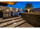 Modern outdoor kitchen boasts stainless steel appliances, stylish countertops, and a built-in pizza oven at 10381 E Loving Tree Ln, Scottsdale, AZ 85262