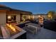 Desert backyard with an outdoor kitchen featuring a pizza oven and a fire pit area at 10381 E Loving Tree Ln, Scottsdale, AZ 85262
