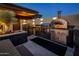 Outdoor kitchen with stainless steel appliances, pizza oven, and stylish countertops at 10381 E Loving Tree Ln, Scottsdale, AZ 85262