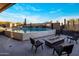 Outdoor area featuring a pool with waterfalls and textured wall, a fire pit, an outdoor TV, and lounge chairs at 10381 E Loving Tree Ln, Scottsdale, AZ 85262