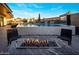 Outdoor living space with a fire pit, pool with waterfall features, an outdoor television, and comfortable lounge chairs at 10381 E Loving Tree Ln, Scottsdale, AZ 85262
