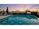 Inviting backyard pool area features a built-in fire pit, waterfall features, and an outdoor television at 10381 E Loving Tree Ln, Scottsdale, AZ 85262