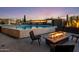 Inviting pool area features a built-in fire pit, waterfall features, an outdoor television, and lounge seating at 10381 E Loving Tree Ln, Scottsdale, AZ 85262
