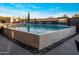 Beautiful pool featuring a textured pool wall, waterfall features, and an outdoor television, surrounded by dark stone at 10381 E Loving Tree Ln, Scottsdale, AZ 85262