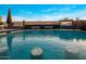 A luxurious pool featuring a swim-up bar, dual waterfall features and an outdoor TV with a desert sunset scene at 10381 E Loving Tree Ln, Scottsdale, AZ 85262
