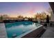 Inviting backyard pool area features a built-in fire pit, waterfall features, and an outdoor television at 10381 E Loving Tree Ln, Scottsdale, AZ 85262