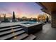 Outdoor oasis featuring a pool, spa, fire features, lounge chairs, and an outdoor television for ultimate relaxation at 10381 E Loving Tree Ln, Scottsdale, AZ 85262