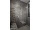 Close up of a luxurious shower with stunning stone tile and modern fixtures at 10381 E Loving Tree Ln, Scottsdale, AZ 85262