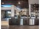 Stylish wet bar with dark wood cabinets, stainless steel appliances, and a stone accent wall at 10381 E Loving Tree Ln, Scottsdale, AZ 85262