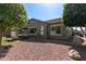 View of gravel backyard featuring an in-ground jacuzzi with a dark gray exterior and a glimpse of the covered patio at 10822 E Ramblewood Cir, Mesa, AZ 85212