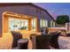 Inviting backyard featuring a hot tub, outdoor seating, and views into the brightly lit living room at 10822 E Ramblewood Cir, Mesa, AZ 85212
