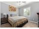 Cozy bedroom with a queen bed, bedside table, hardwood floors, and a shuttered window at 10822 E Ramblewood Cir, Mesa, AZ 85212