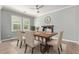 Formal dining room with a modern ceiling fan, stylish furniture, and abundant natural light from large windows at 10822 E Ramblewood Cir, Mesa, AZ 85212