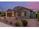 Well-lit home featuring a brown garage door, desert landscaping, and a drought-resistant yard at 10822 E Ramblewood Cir, Mesa, AZ 85212