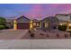 Charming single-story home featuring desert landscaping, accent lighting and a brick-paved driveway at 10822 E Ramblewood Cir, Mesa, AZ 85212