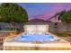 Backyard hot tub featuring mood lighting, a well-manicured lawn, and lush landscaping at 10822 E Ramblewood Cir, Mesa, AZ 85212