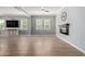 Spacious living room with wood-look tile flooring, a modern ceiling fan and a wall-mounted electric fireplace at 10822 E Ramblewood Cir, Mesa, AZ 85212