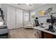 Bright office featuring wood look flooring, white armchair, and a modern desk at 10822 E Ramblewood Cir, Mesa, AZ 85212