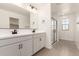 Elegant bathroom featuring a double vanity, large mirror, and a glass-enclosed shower at 11619 W Green Dr, Youngtown, AZ 85363