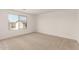 Cozy bedroom with soft carpeting and a window overlooking the neighborhood at 11619 W Green Dr, Youngtown, AZ 85363