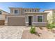 Two-story home with a two-car garage, paver driveway, and desert landscaping in a peaceful neighborhood at 11619 W Green Dr, Youngtown, AZ 85363