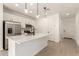 Well-lit kitchen featuring stainless steel appliances, white cabinets, and a quartz countertop island at 11619 W Green Dr, Youngtown, AZ 85363