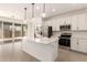 Open kitchen with stainless appliances, a center island, and sliding glass doors leading to the backyard at 11619 W Green Dr, Youngtown, AZ 85363