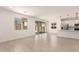 Bright and airy living area with tile floors, large windows, and an open layout to the kitchen at 11619 W Green Dr, Youngtown, AZ 85363