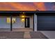 Close-up of house with dark front door and garage under a dramatic sky with decorative rock landscape at 12444 N 33Rd St, Phoenix, AZ 85032