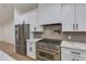 Modern kitchen with stainless steel appliances, white cabinets, and light countertops at 12444 N 33Rd St, Phoenix, AZ 85032