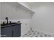 Modern laundry room featuring a sleek black sink, gray cabinetry, and patterned tile flooring at 12444 N 33Rd St, Phoenix, AZ 85032