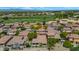 Expansive aerial view captures a community with well-maintained homes, green spaces, and a golf course in the background at 13587 W Cypress St, Goodyear, AZ 85395