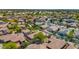 Wide aerial shot displaying a neighborhood with tile roofs, verdant landscaping, and community amenities in the distance at 13587 W Cypress St, Goodyear, AZ 85395