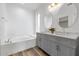 Bright bathroom featuring double sinks, a tub, and updated fixtures at 13587 W Cypress St, Goodyear, AZ 85395