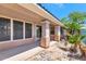 Covered patio features tan columns and a pebble landscape design with small palm trees in the backyard at 13587 W Cypress St, Goodyear, AZ 85395