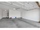 Spacious garage with white walls and ceiling, cement floor, and an automatic garage door opener at 13587 W Cypress St, Goodyear, AZ 85395