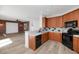 Updated kitchen featuring wood cabinets, sleek appliances, and views of a brick wall living room at 13587 W Cypress St, Goodyear, AZ 85395