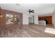 Inviting living room showcases wood-look floors, a brick wall, and transitions into the dining and kitchen areas at 13587 W Cypress St, Goodyear, AZ 85395