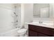 A well-lit bathroom featuring a tub with shower, modern vanity, and a sleek mirror at 17263 N Bala Dr, Maricopa, AZ 85138