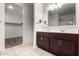 Bathroom featuring double sink vanity and walk-in closet with built-in shelves, providing ample storage at 17263 N Bala Dr, Maricopa, AZ 85138