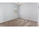 Neutral-toned bedroom featuring a large window, soft carpeting, and ample natural light at 17263 N Bala Dr, Maricopa, AZ 85138