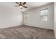 Spacious bedroom featuring plush carpeting, ceiling fan, and bright natural light from multiple windows at 17263 N Bala Dr, Maricopa, AZ 85138