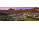 Lush desert landscape featuring a luxury home on a mountainside overlooking a green golf course at 20179 W Highland Ave, Litchfield Park, AZ 85340