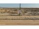 Vacant lot with a 'Diamante' sign posted on a saguaro, amidst desert vegetation at 20179 W Highland Ave, Litchfield Park, AZ 85340