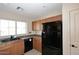 Functional kitchen with a black fridge and updated appliances for modern convenience at 21047 N Alma Dr, Maricopa, AZ 85138