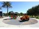 Community playground featuring colorful play structures, a covered picnic area, and mature shade trees at 21047 N Alma Dr, Maricopa, AZ 85138