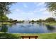 Picturesque pond with fountain, bench seating, and landscaped surroundings at 21047 N Alma Dr, Maricopa, AZ 85138