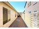 Narrow side yard with brick pathway, decorative stone, and mature hedges at 21047 N Alma Dr, Maricopa, AZ 85138